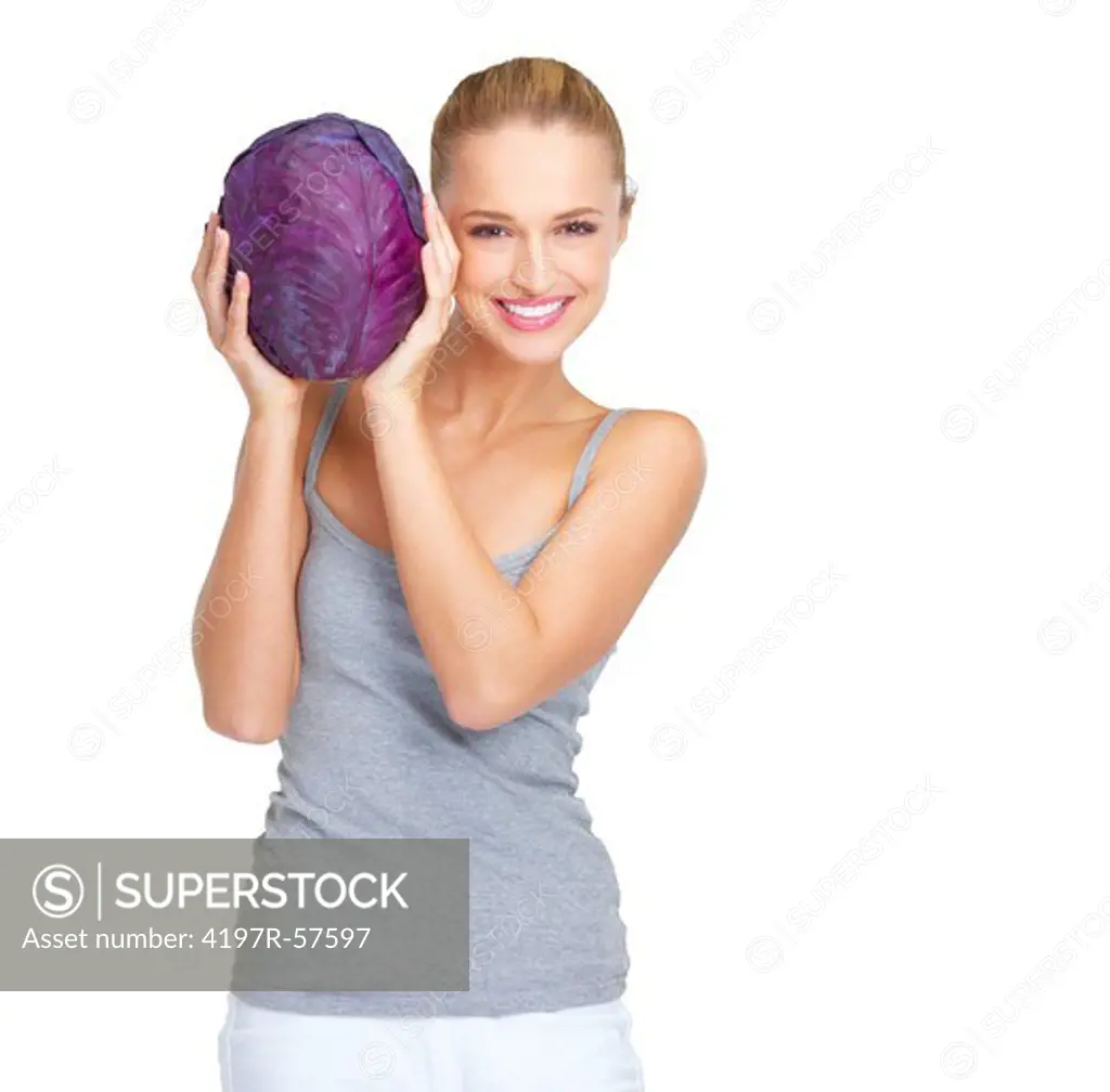 Lovely young woman holding up a head of purple cabbage with a smile