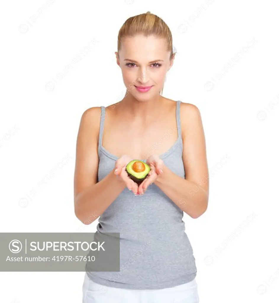 Lovely young woman holding up a half an avocado pear