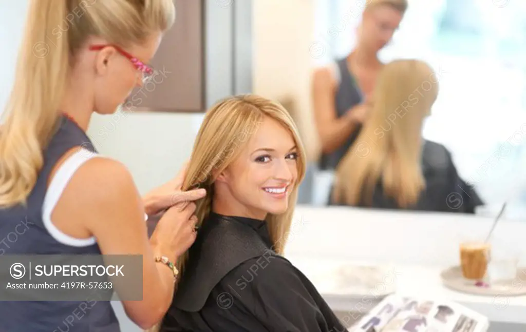 Pretty young woman smiling while having a consultation with her hair stylist