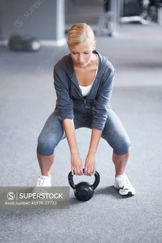 An attractive young woman exercising with a weighted ball in the gym