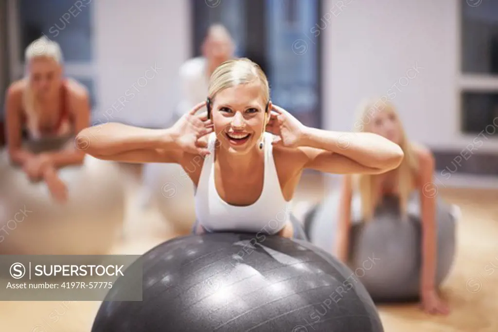 Portrait of an attractive young woman working with her aerobics class using exercise balls