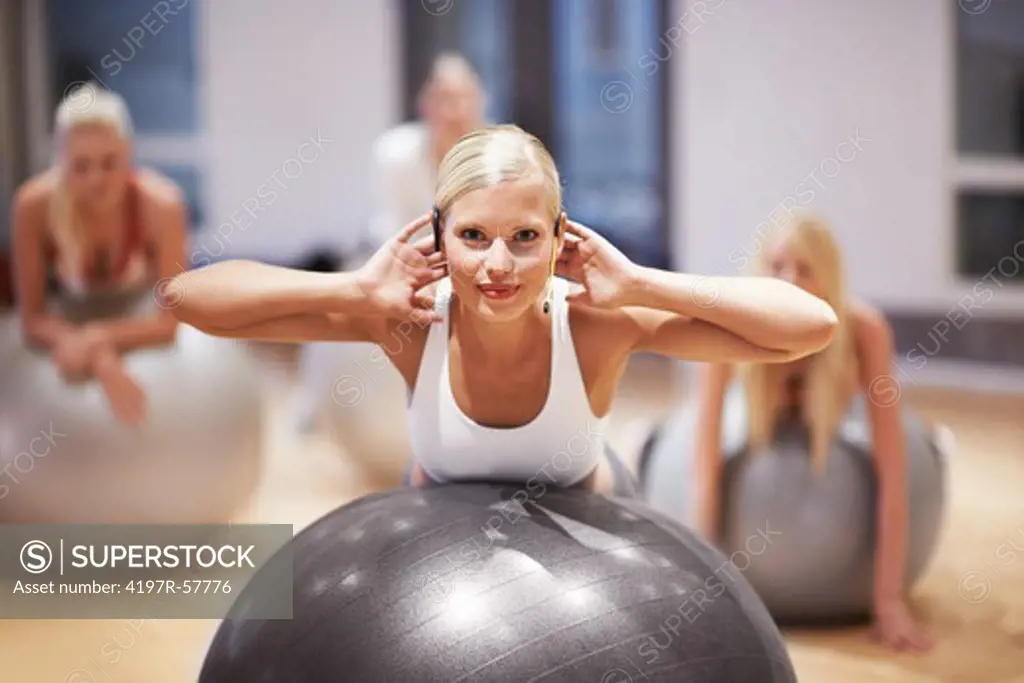 Portrait of a beautiful young woman working with her aerobics class using exercise balls