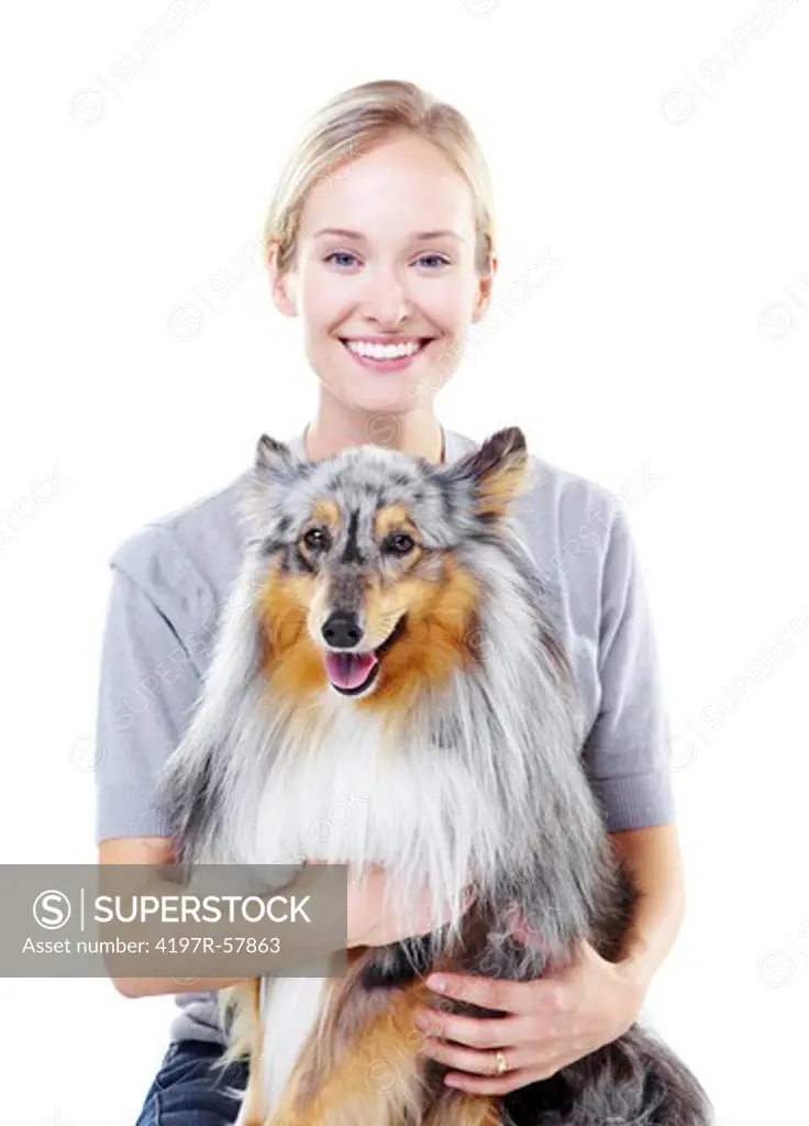 Happy young dog owner holding her shetland sheepdog with a smile