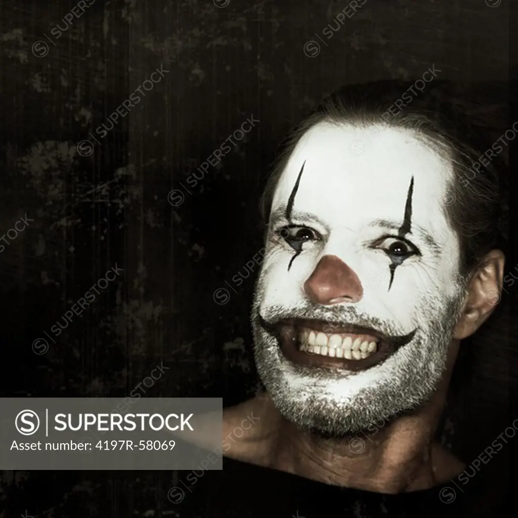 Portrait of an evil clown with face paint on a black background