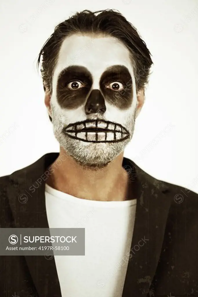 Portrait of a man with his face painted like a skull for Halloween on a white background