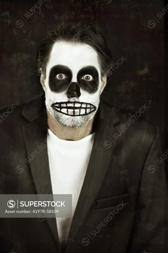 Portrait of a man with his face painted like a skull for Halloween on a black background
