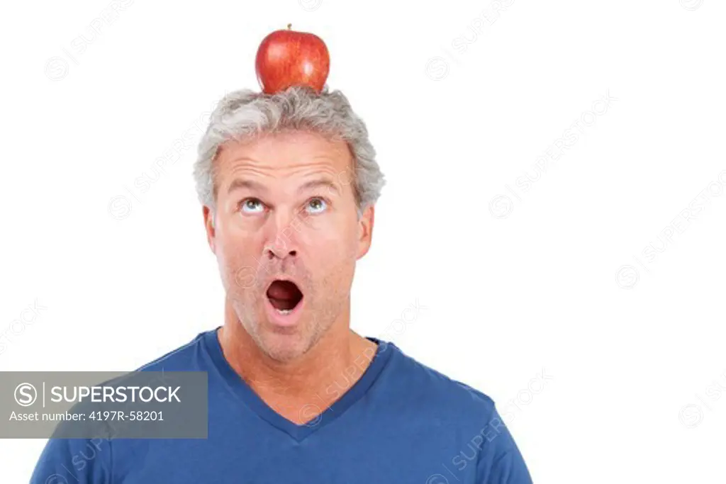 A handsome mature man looking at the apple atop his head pleading for it to stay there