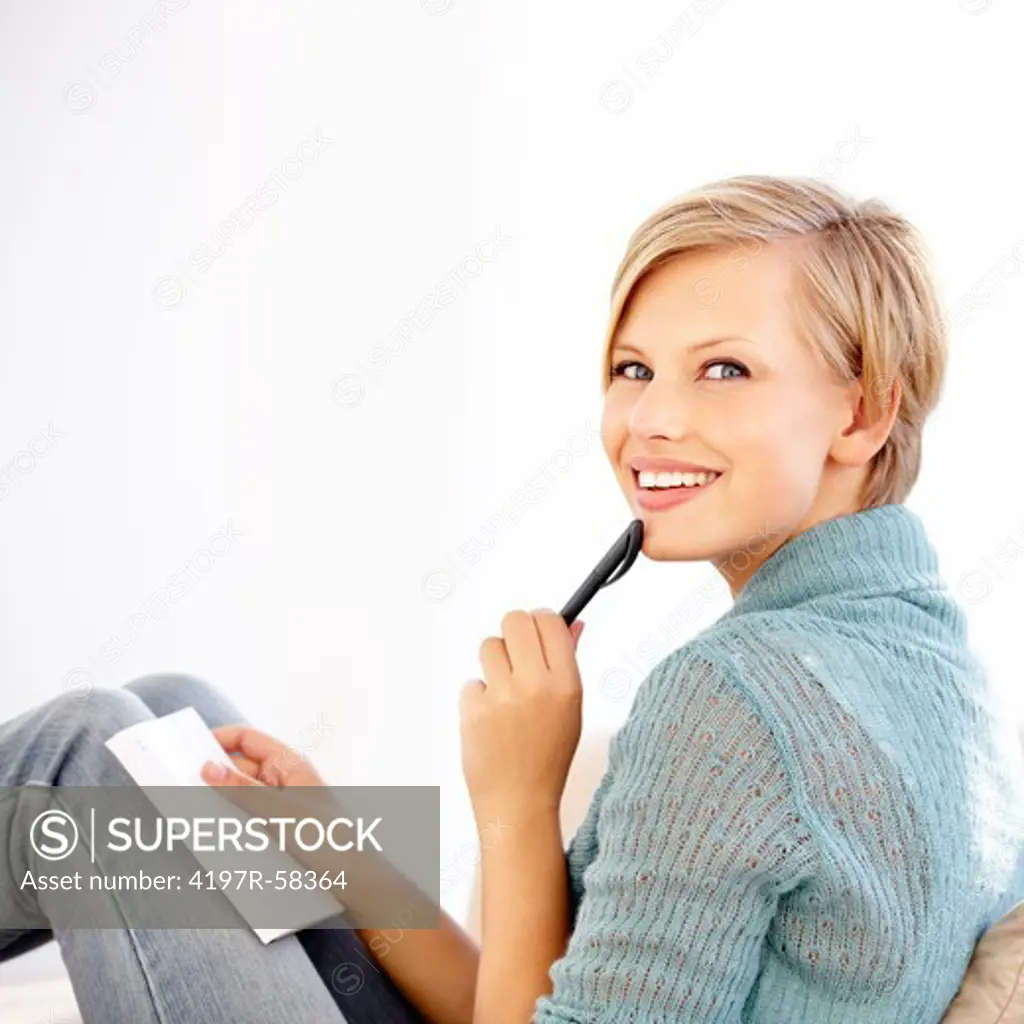 An attractive young woman looking at the camera as she thinks about what to write