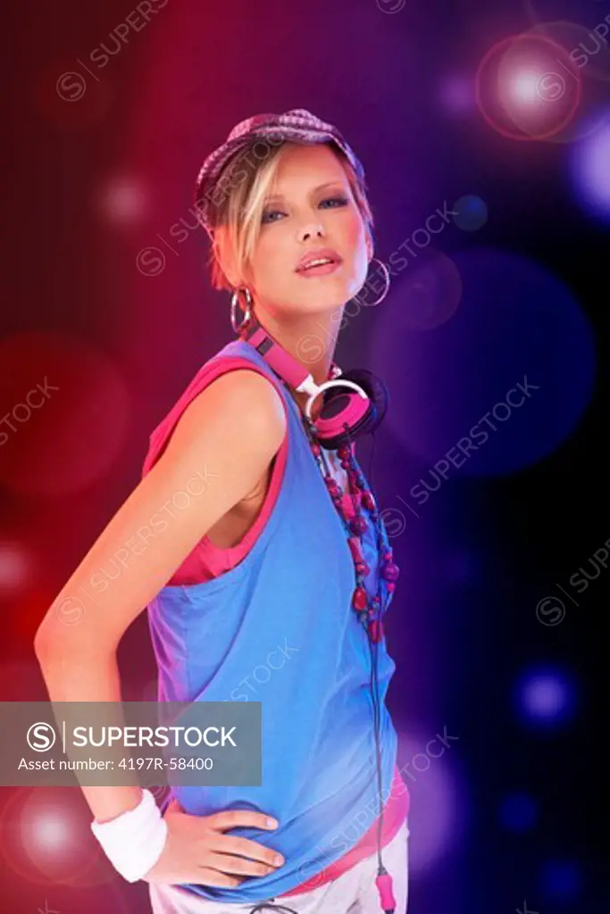 Trendy young girl in urban attire against a background of colored lights