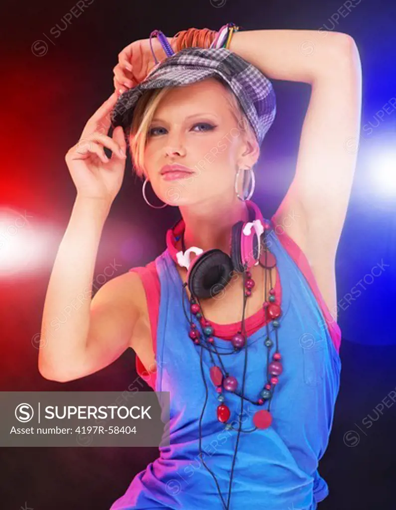 Trendy young girl in urban attire giving you attitude against a background of colored lights