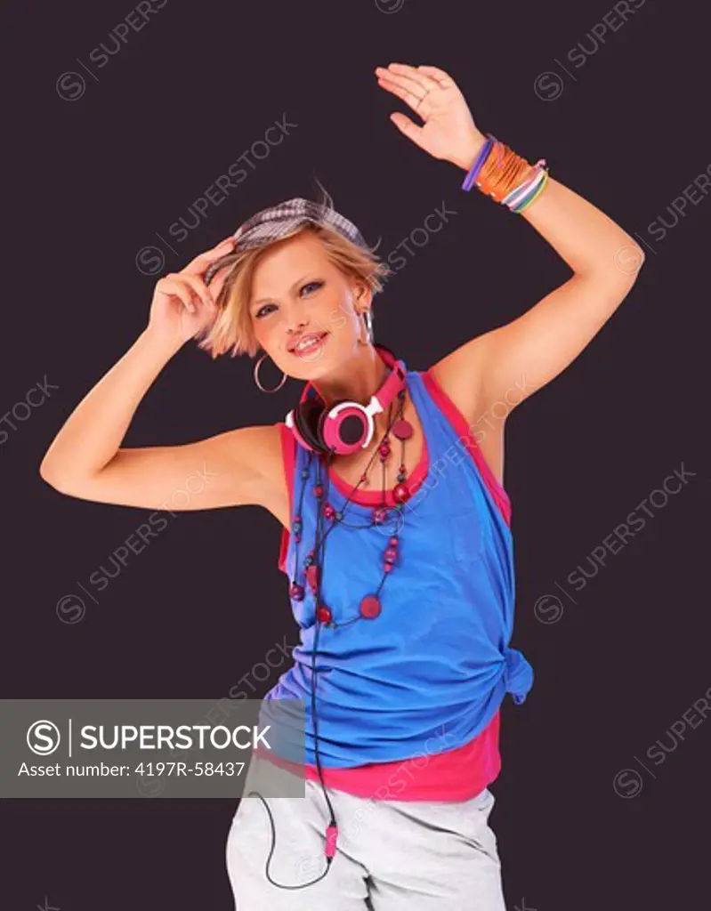 Trendy young girl in urban attire dancing against a background of colored lights and strobe effects