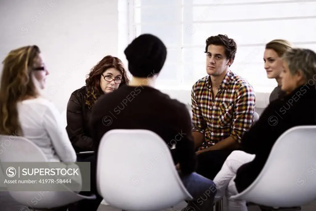 A group of young people talking to each other during therapy