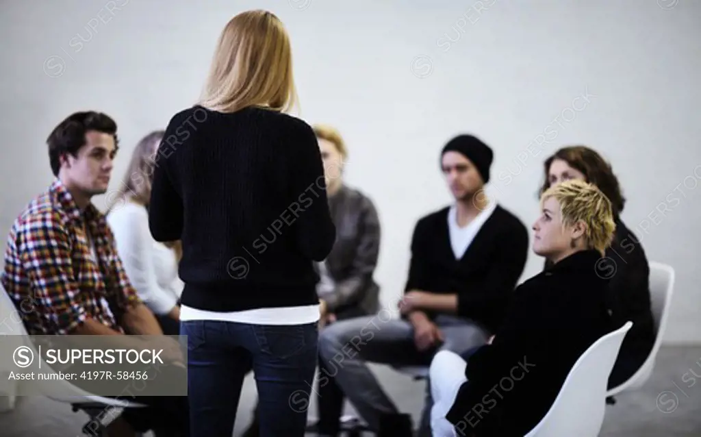 A young woman addressing members of her support group