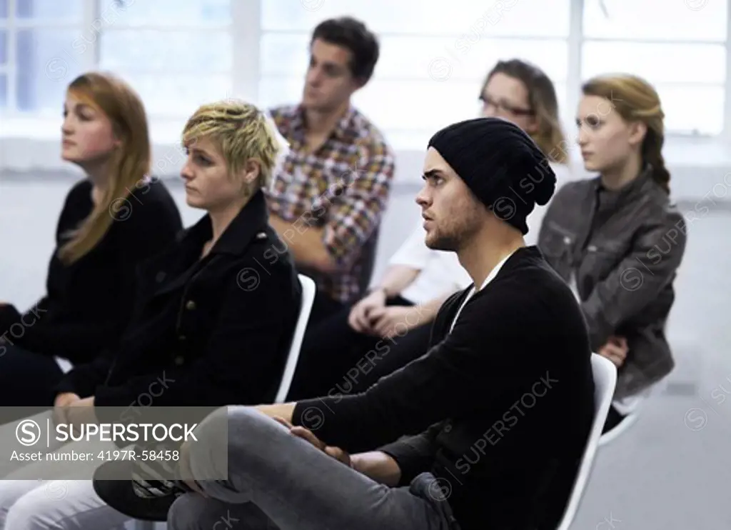 A group of people listening intently to their psychologist druing a support group session