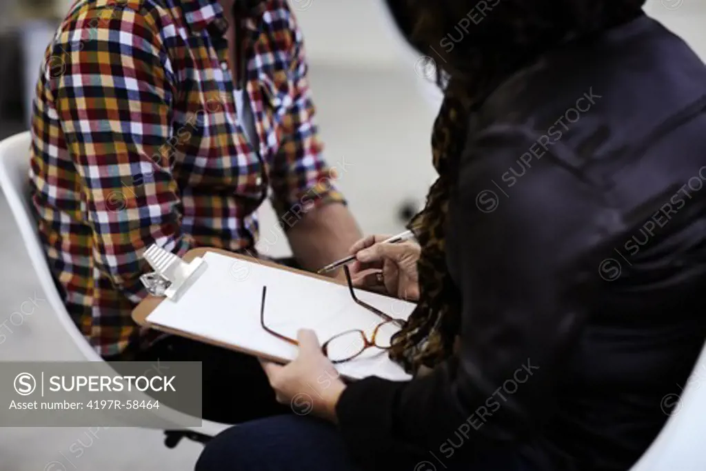 A cropped shot of a therapist taking down a patient's details