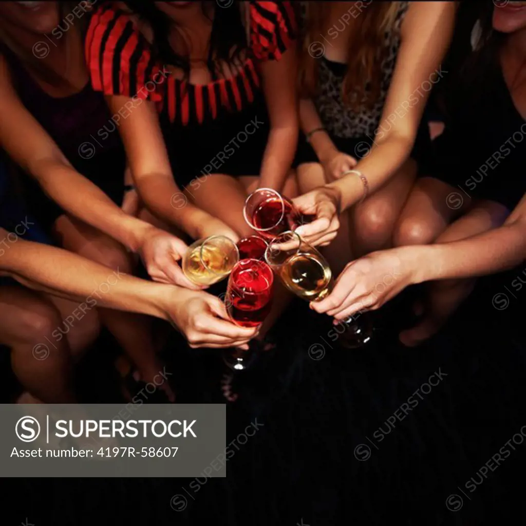 A group of girls toasting wine to an awesome night of partying ahead