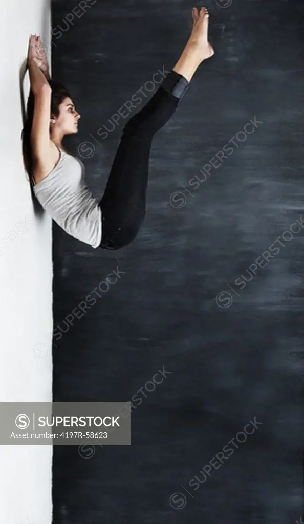 Tilted studio shot of a young woman with her legs raised - mental illness concept