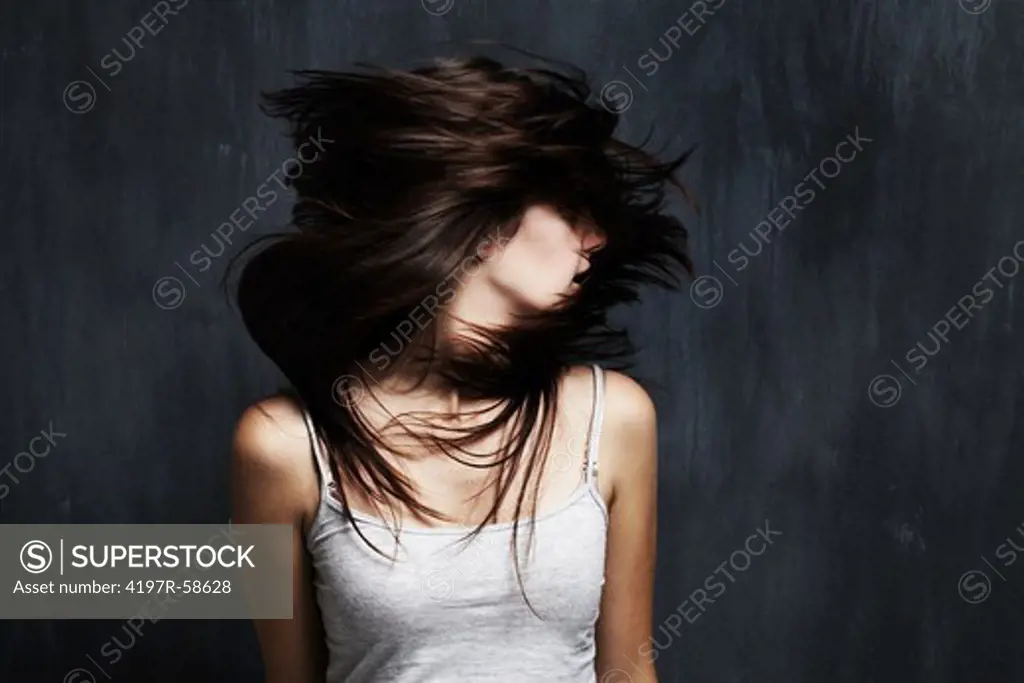 A studio concept shot of a mentally distressed young woman shaking her head around