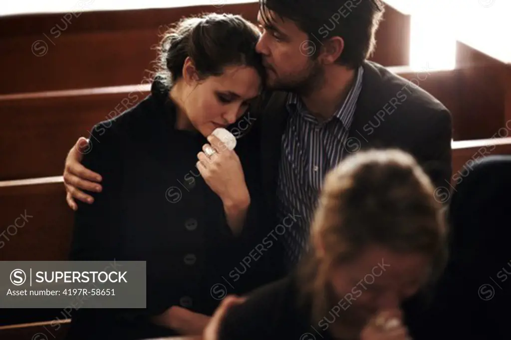 A family crying at a funeral service in a church