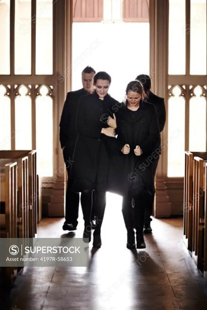 A family of mourners entering a church to attend a funeral