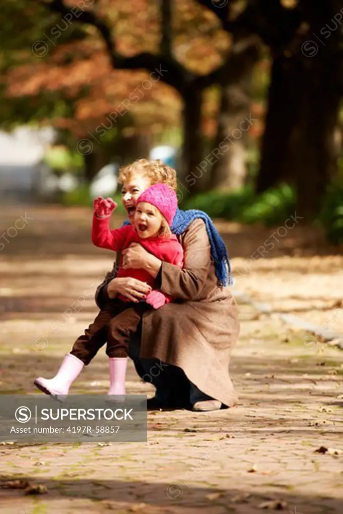 A grandmother playing outside with her granddaughter