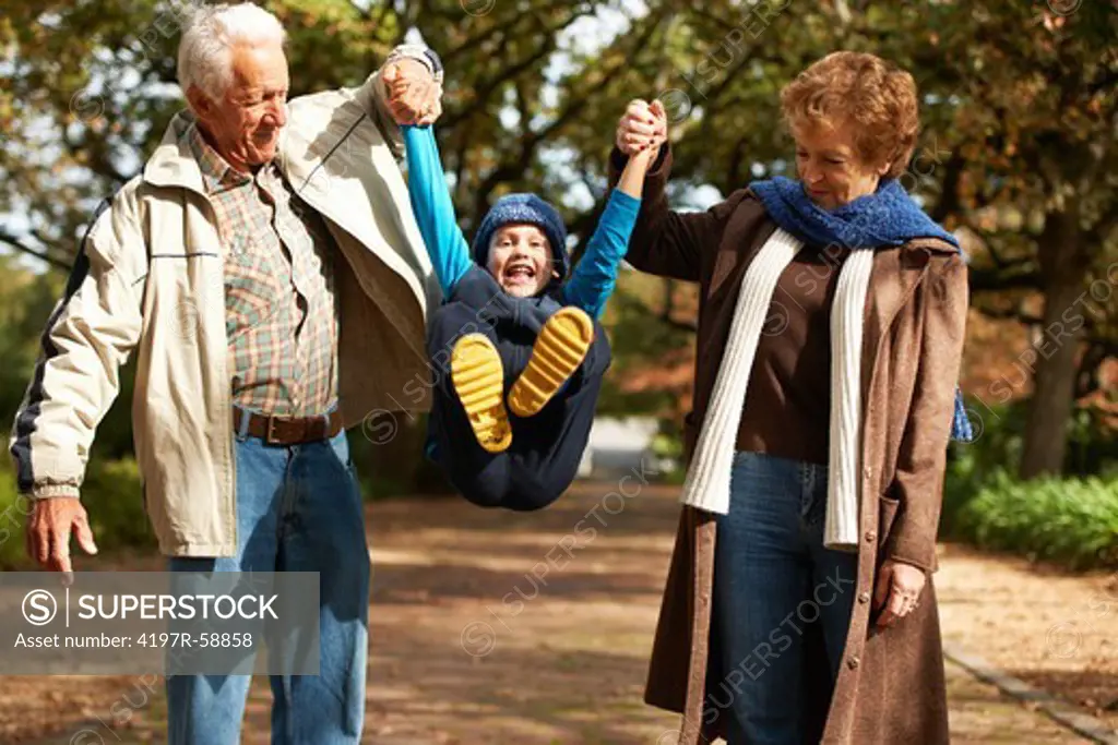 Playful grandparents outside with their grandson