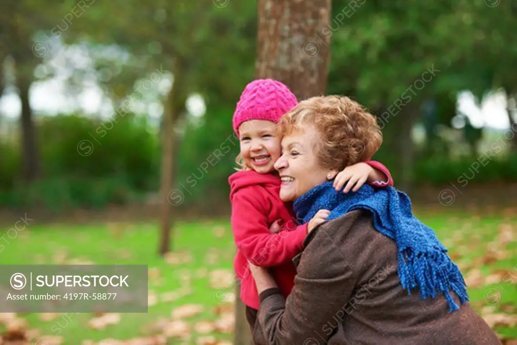 A grandmother embracing her granddaughter outside