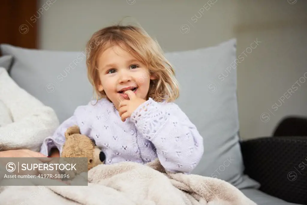 Portrait of a cute little girl sitting on the couch