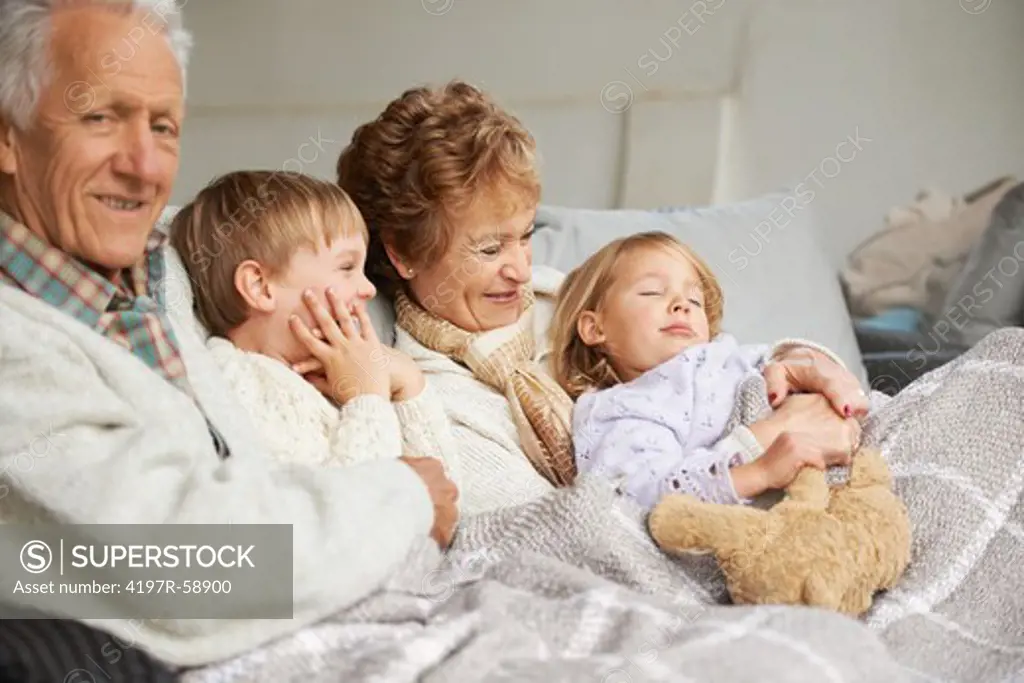 Grandparents relaxing on the couch with their grandchildren