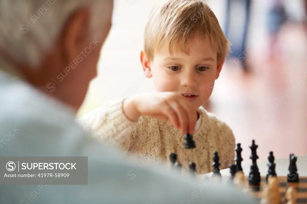 A grandfather playing chess with his grandson