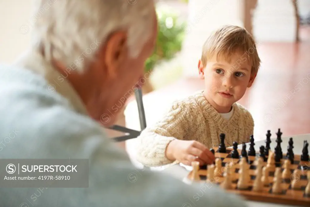 A grandfather and his grandson playing chess