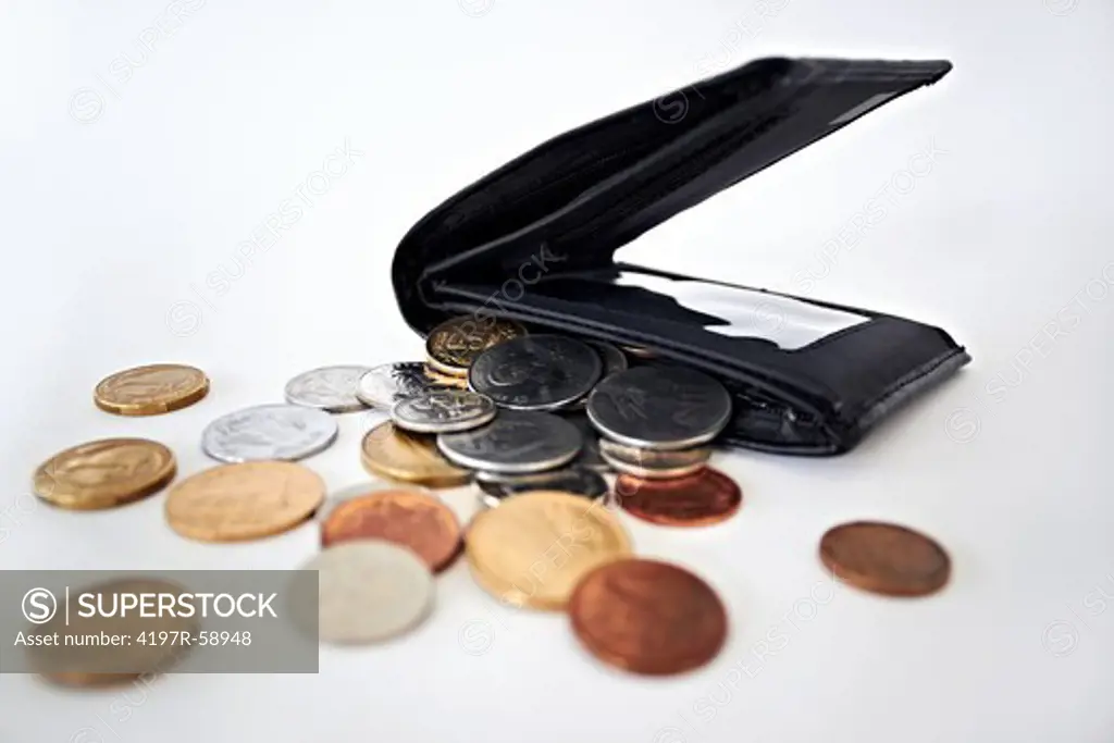 A studio shot of coins spilling out of a wallet