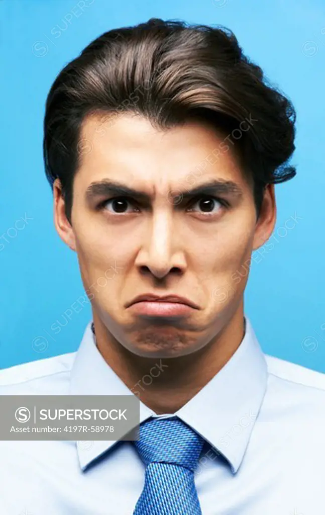 Angry young businessman frowning with a down-turned mouth