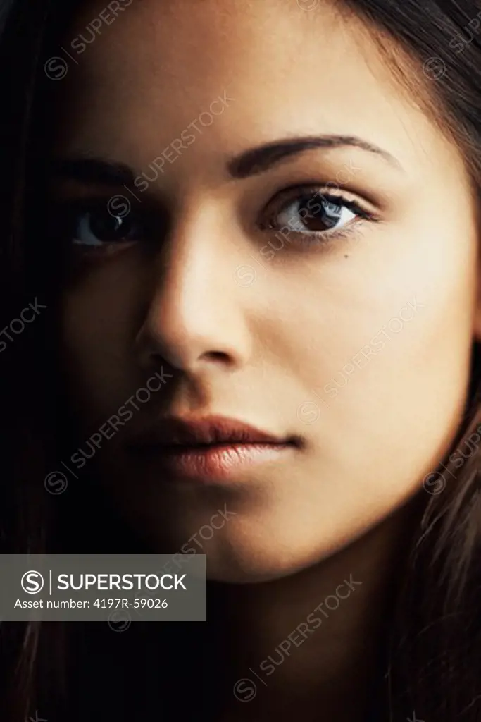Extreme close up of a naturally gorgeous young hispanic woman gazing at you
