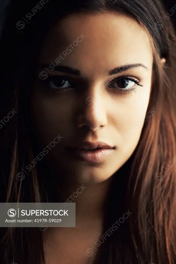 Beatuiful latina woman looking seriously into the camera with deep shadow on her face