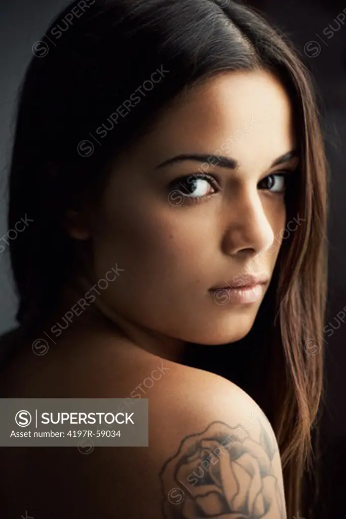 Naturally beautiful latina woman looking at you over her bare shoulder