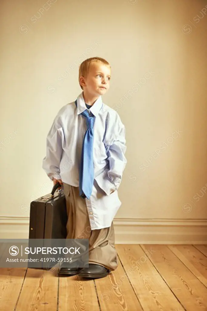 A young boy wearing his dad's work clothes and holding a briefcase
