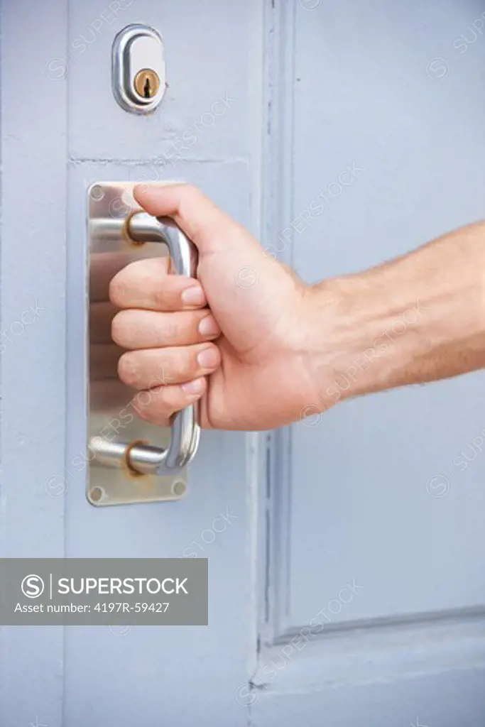 Cropped view of a male hand reaching to open a front door