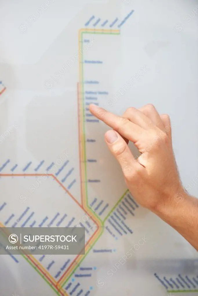 Cropped view of a male hand tracing a route on a transportation terminal map