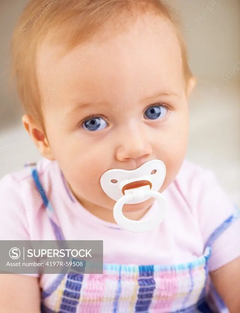 Portrait of a baby with a dummy in his mouth