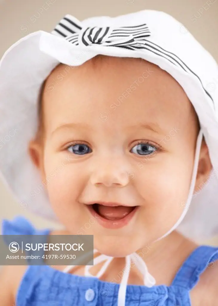 A cute baby girl wearing a hat and smiling