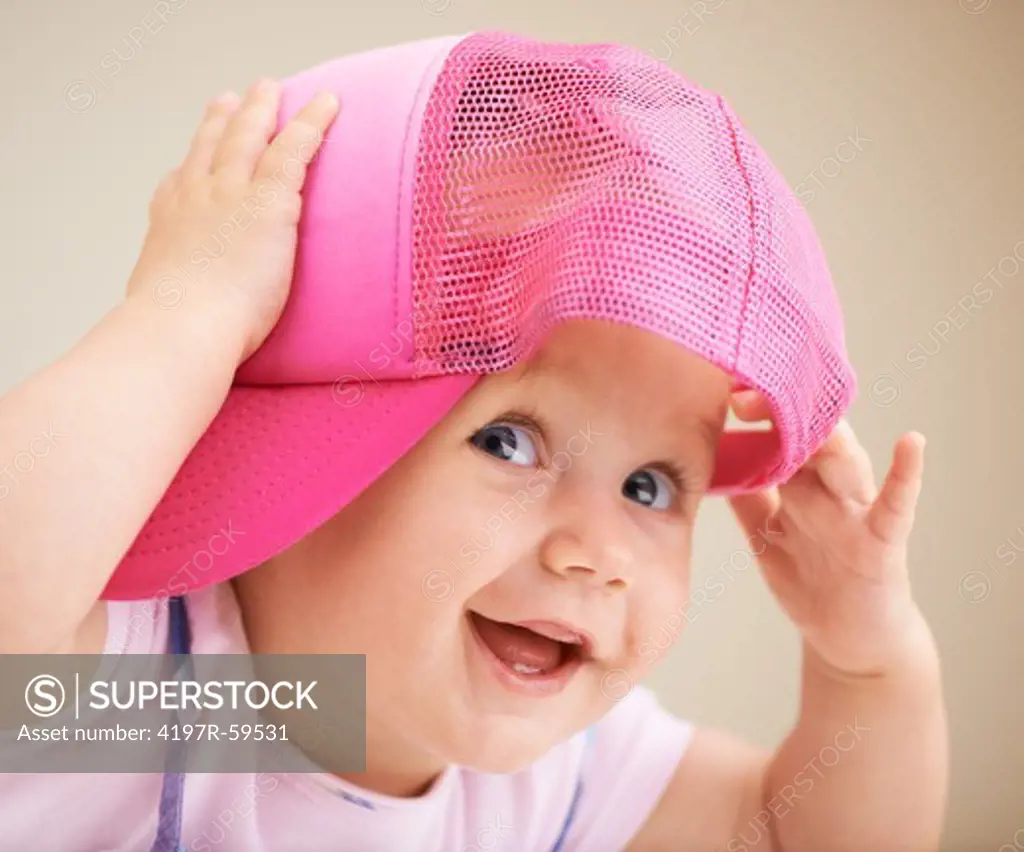 A cute little baby girl wearing an oversized hat
