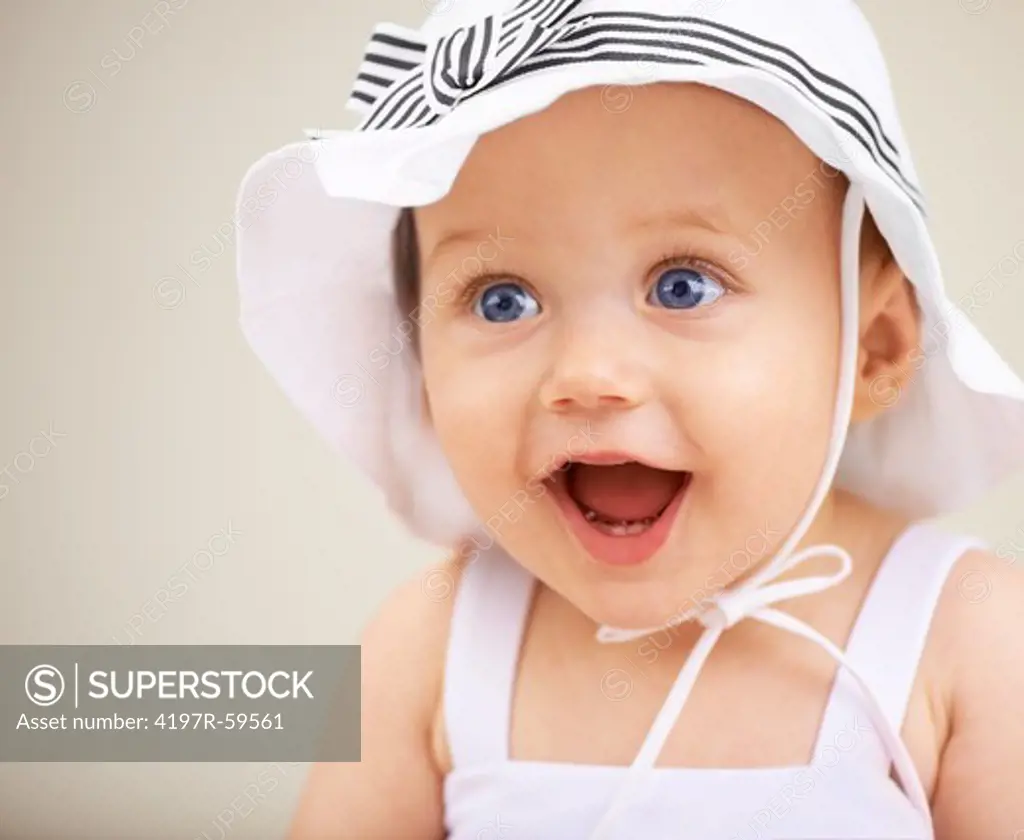 A cute baby girl with a hat smiling