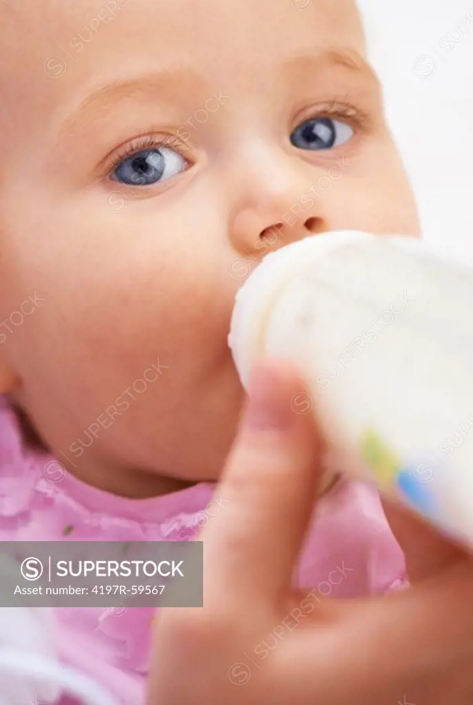 A cute baby girl drinking milk from a bottle