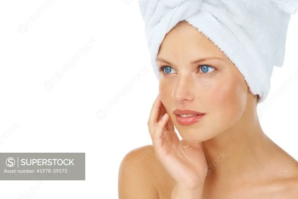 An attractive young woman with a towel on her head on a white background