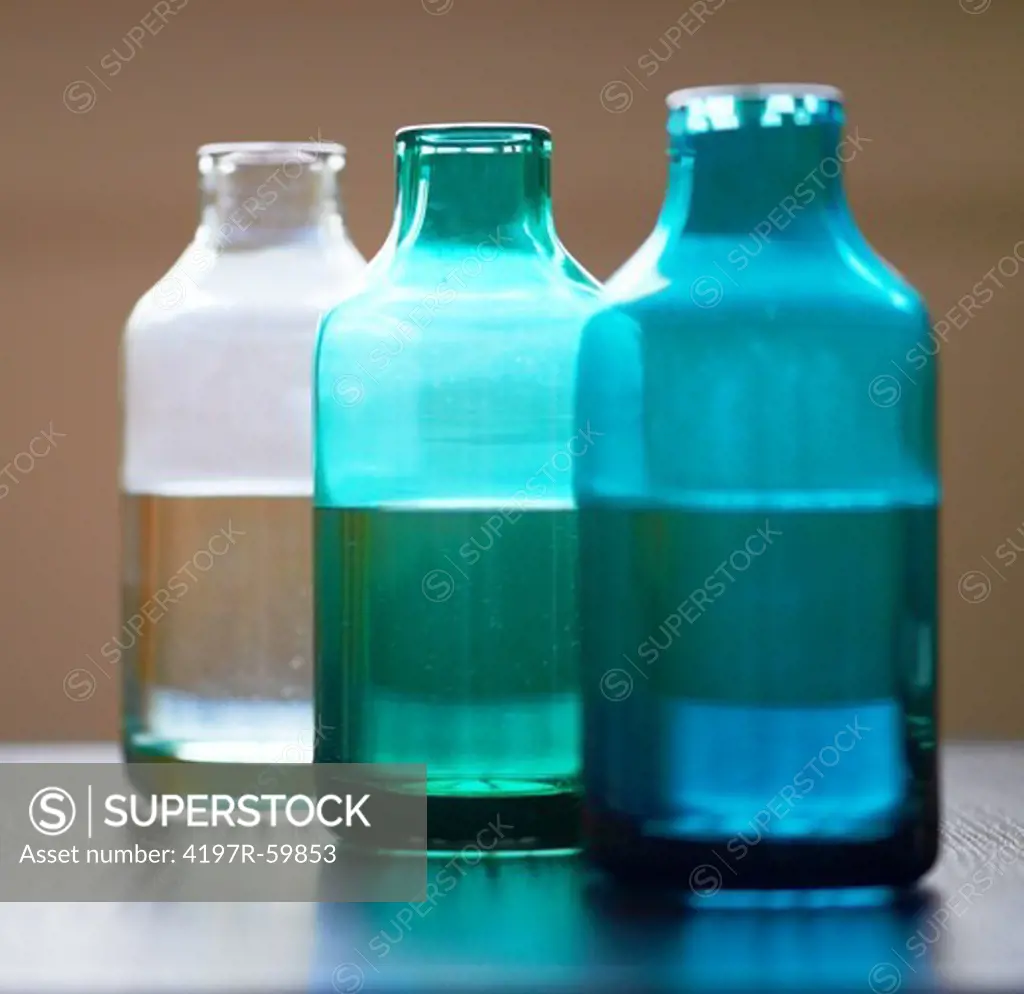 Three jars of differing colour containing water and beauty oils in a receding line - Spa Arrangement