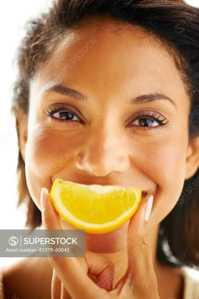 Portrait of an attractive woman holding up an orange wedge in front of her mouth