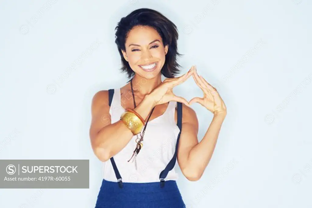 Portrait of a beautiful young ethnic woman making a triangle with her hands