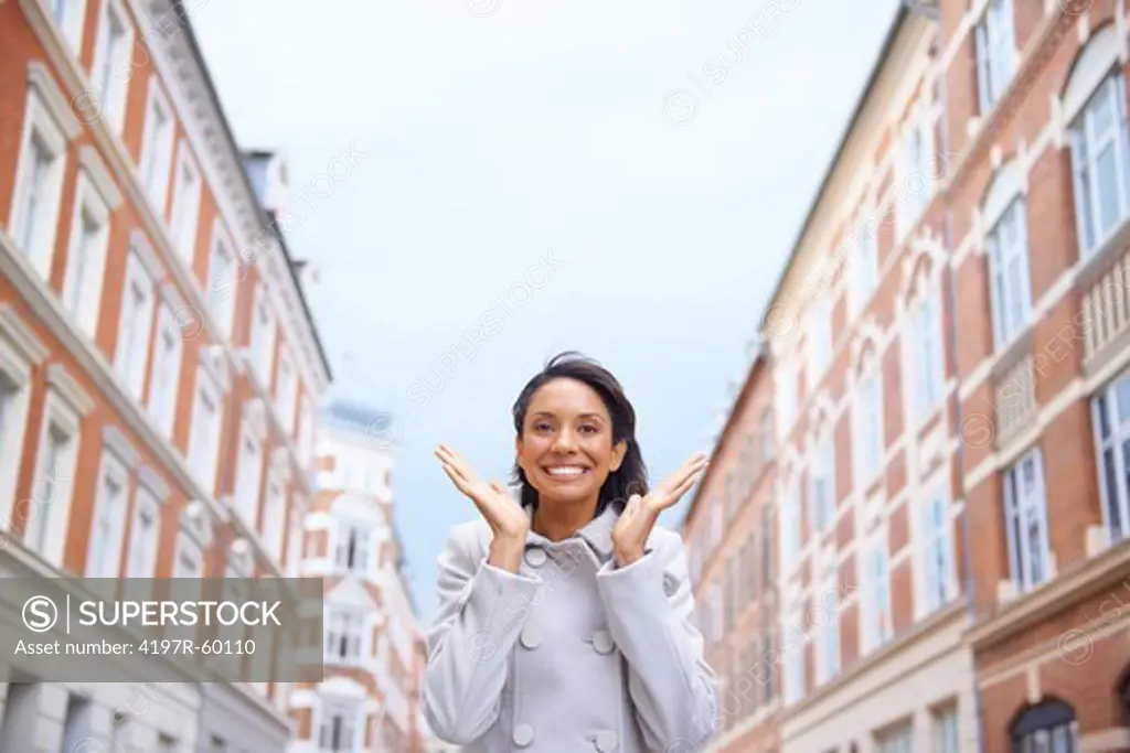 Excited young woman in a macintosh standing in a new city