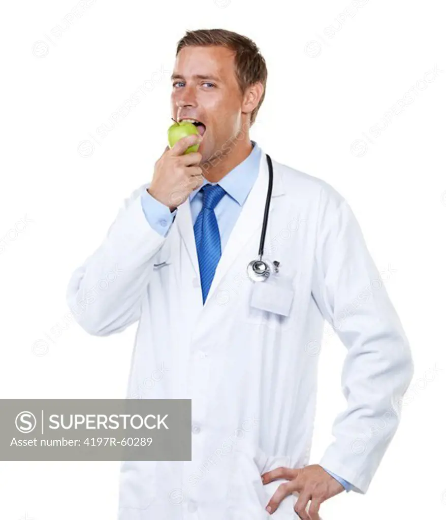 Studio portrait of a young doctor eating an apple isolated on white